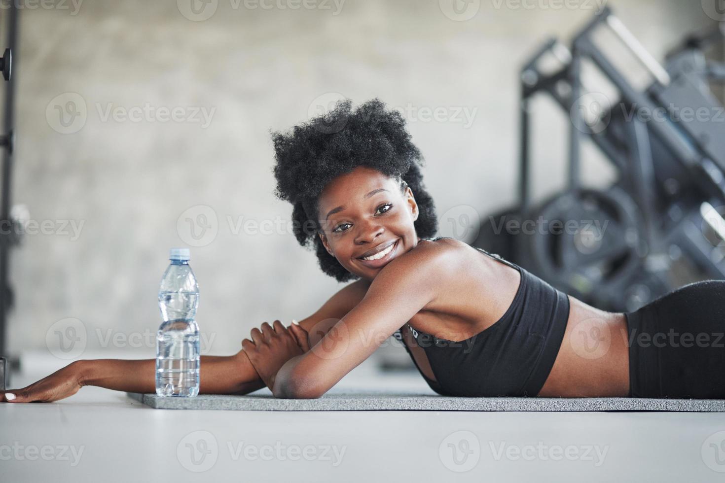 chica feliz. mujer afroamericana con cabello rizado y ropa deportiva tiene  un día de fitness en el gimnasio 15196346 Foto de stock en Vecteezy