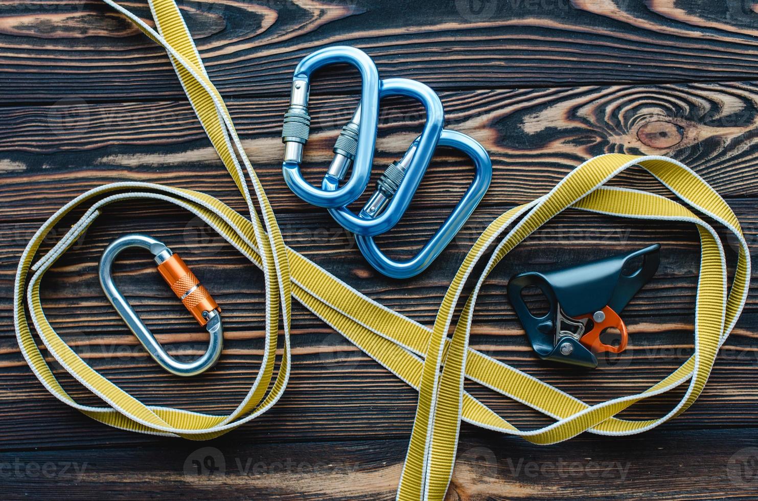 Yellow colored stripe. Isolated photo of climbing equipment. Parts of carabiners lying on the wooden table