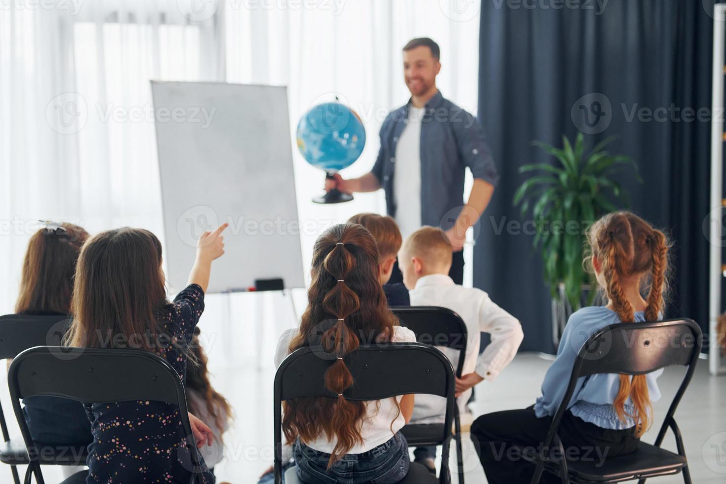 grupo de niños estudiantes en clase en la escuela con el maestro foto