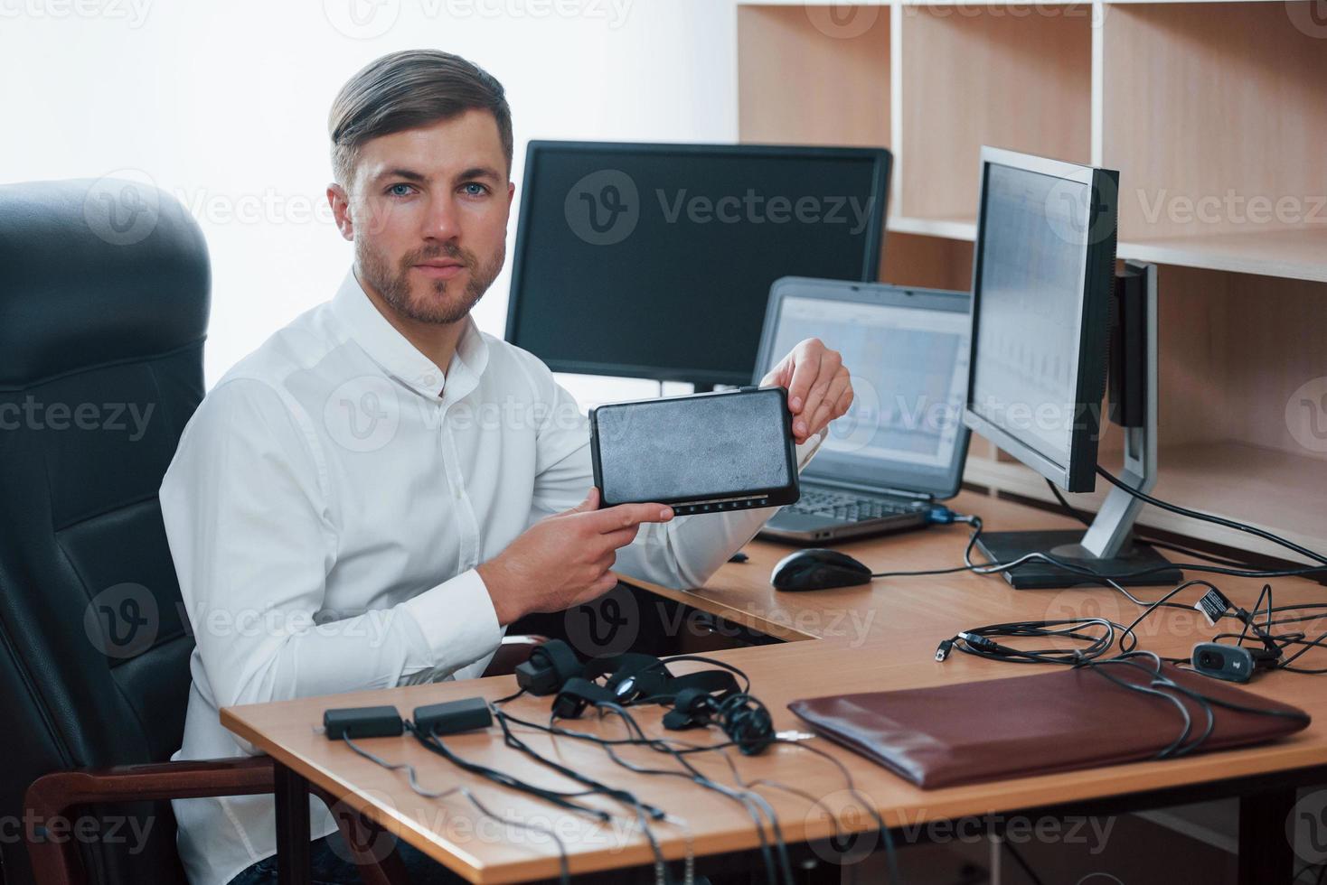 Young professional. Polygraph examiner works in the office with his lie detector's equipment photo