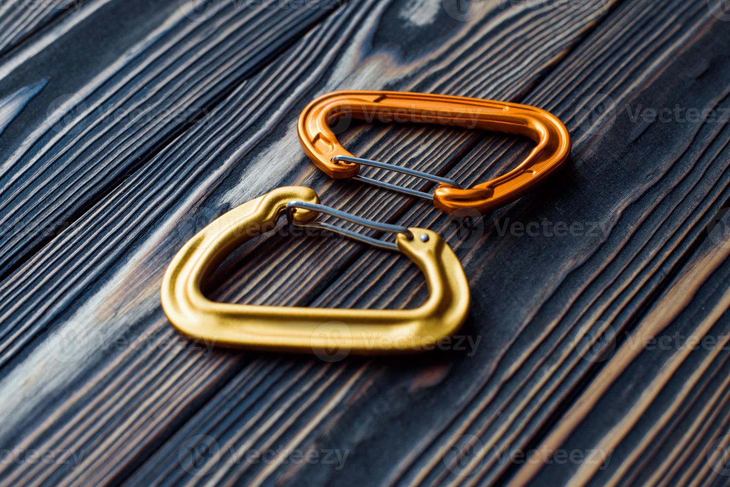Safety first. Isolated photo of climbing equipment. Parts of carabiners lying on the wooden table