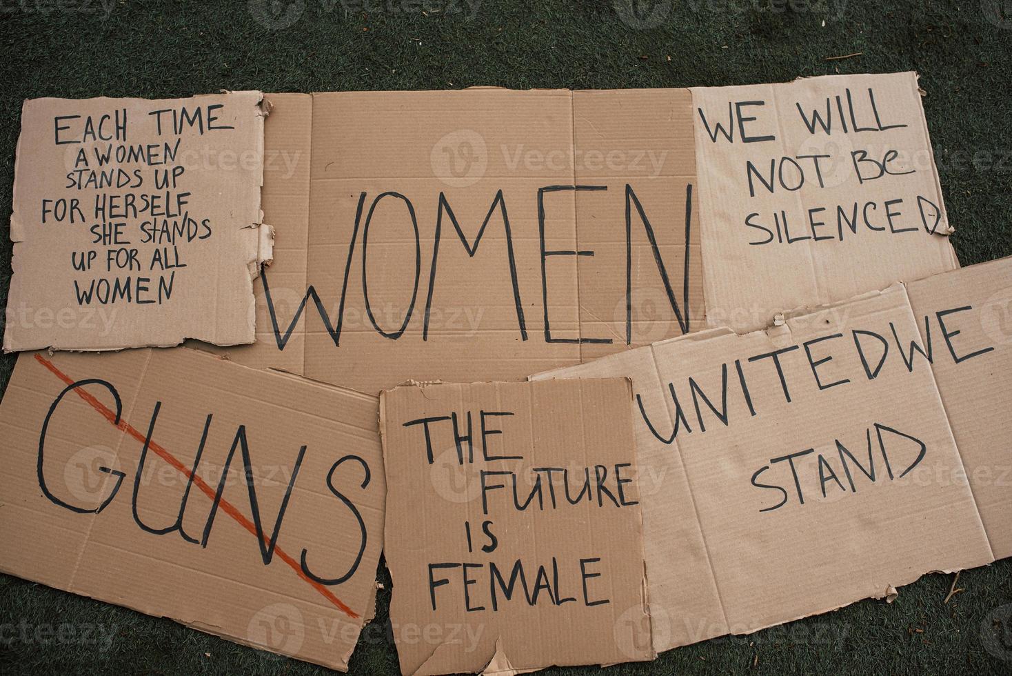 Ready for the riot. Group of banners with different feminist quotes lying on the ground photo