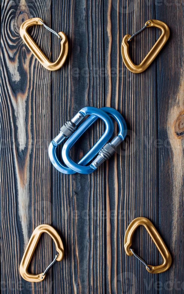 Many of objects. Isolated photo of climbing equipment. Parts of carabiners lying on the wooden table