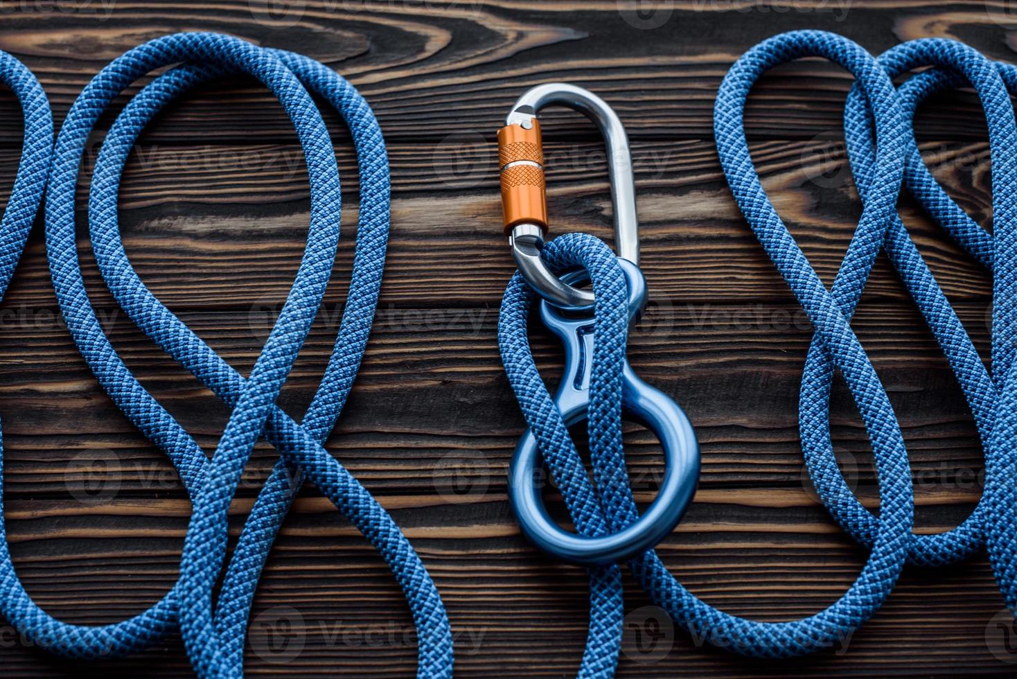 It will withstand your weight. Isolated photo of climbing equipment. Parts of carabiners lying on the wooden table