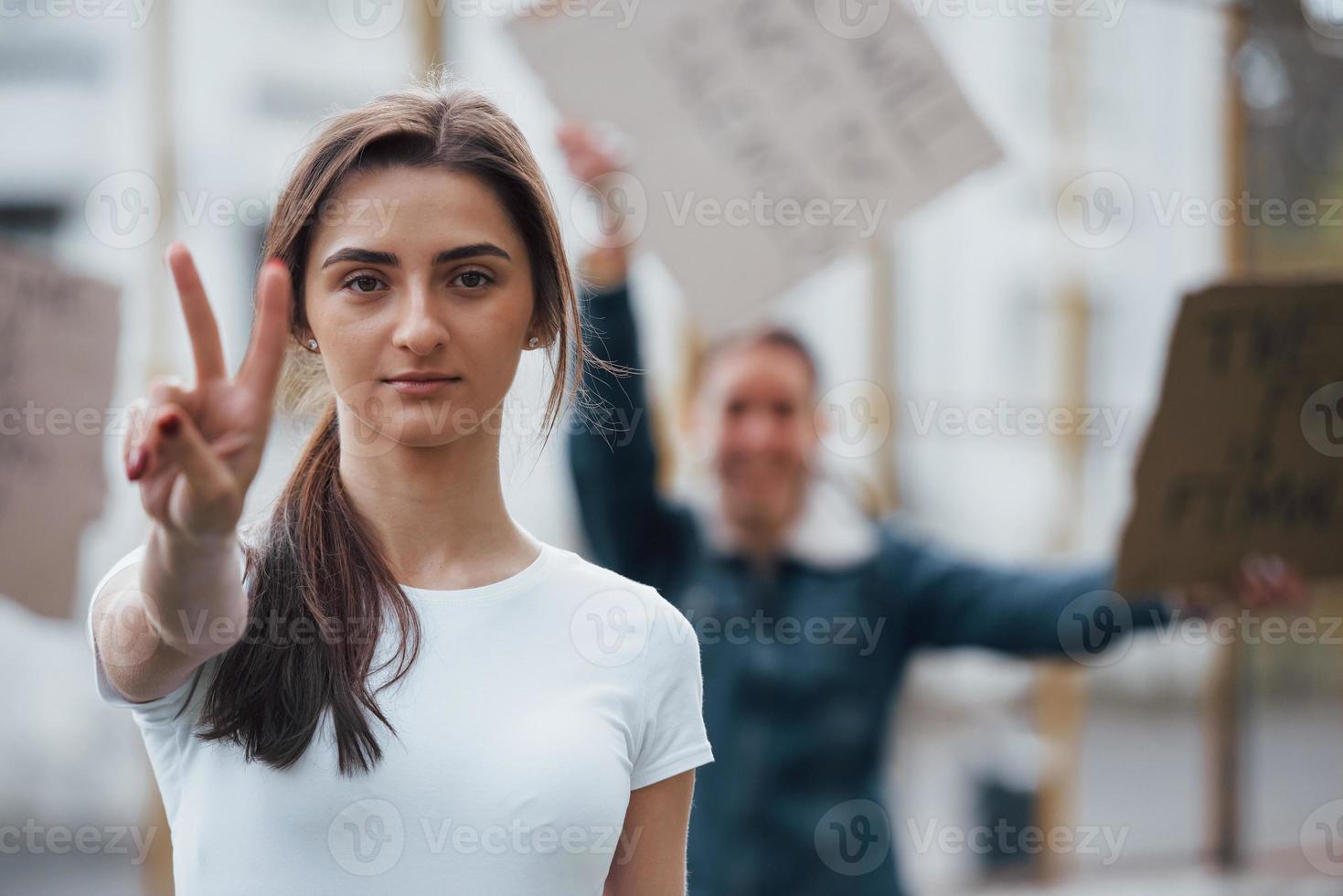 Two fingers gesture. Group of feminist women have protest for their rights outdoors photo