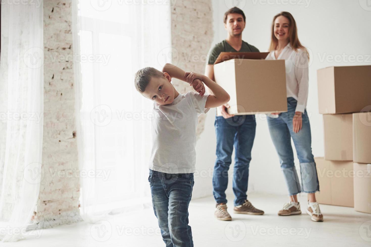 el niño se está divirtiendo. la familia tiene mudanza a una nueva casa. desempacar cajas de mudanza foto