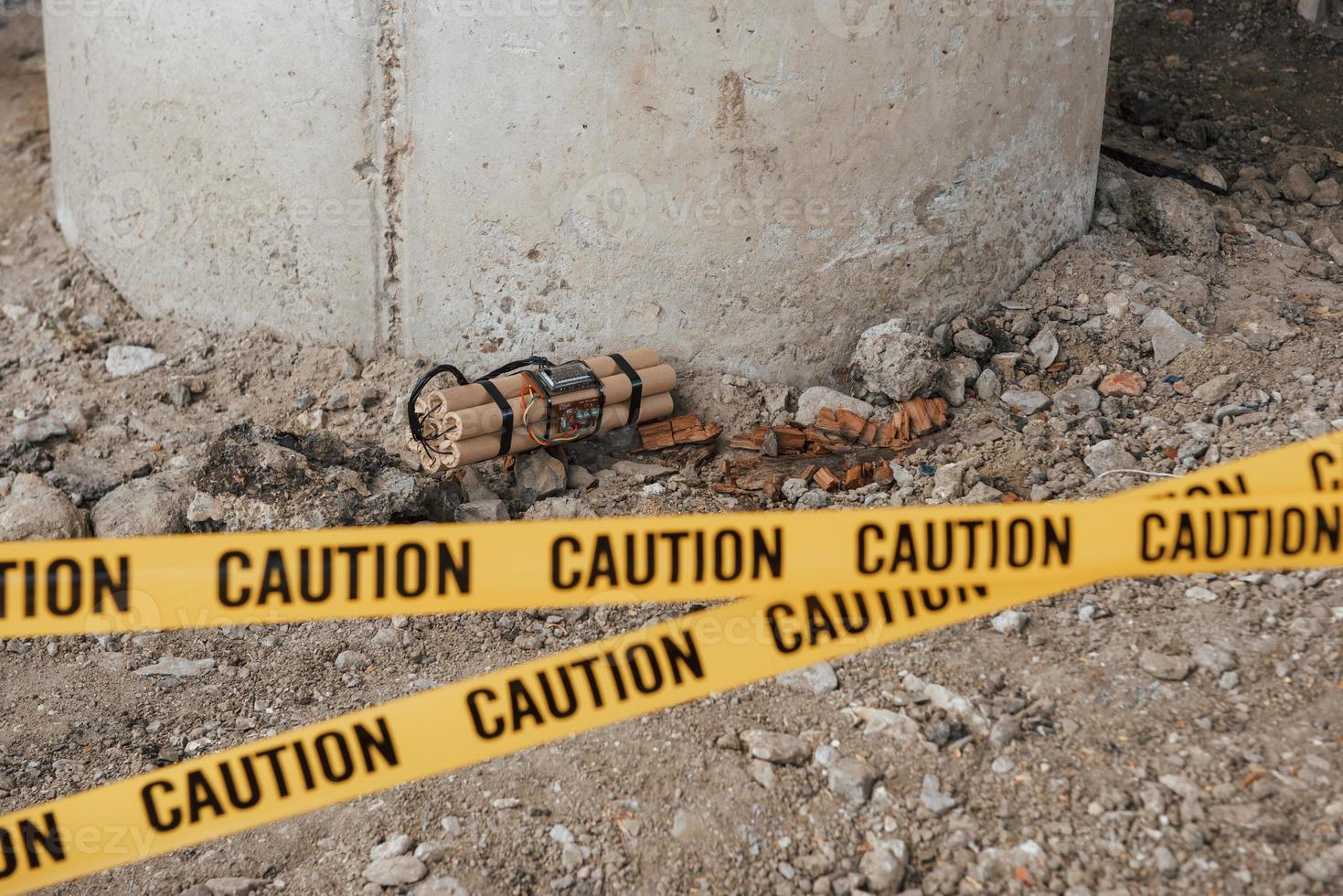 Accident under the bridge. Dangerous explosive lying on the ground. Yellow caution tape in front photo