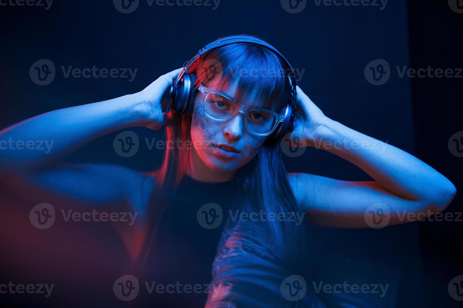 Art of cyberpunk. Studio shot in dark studio with neon light. Portrait of young girl photo