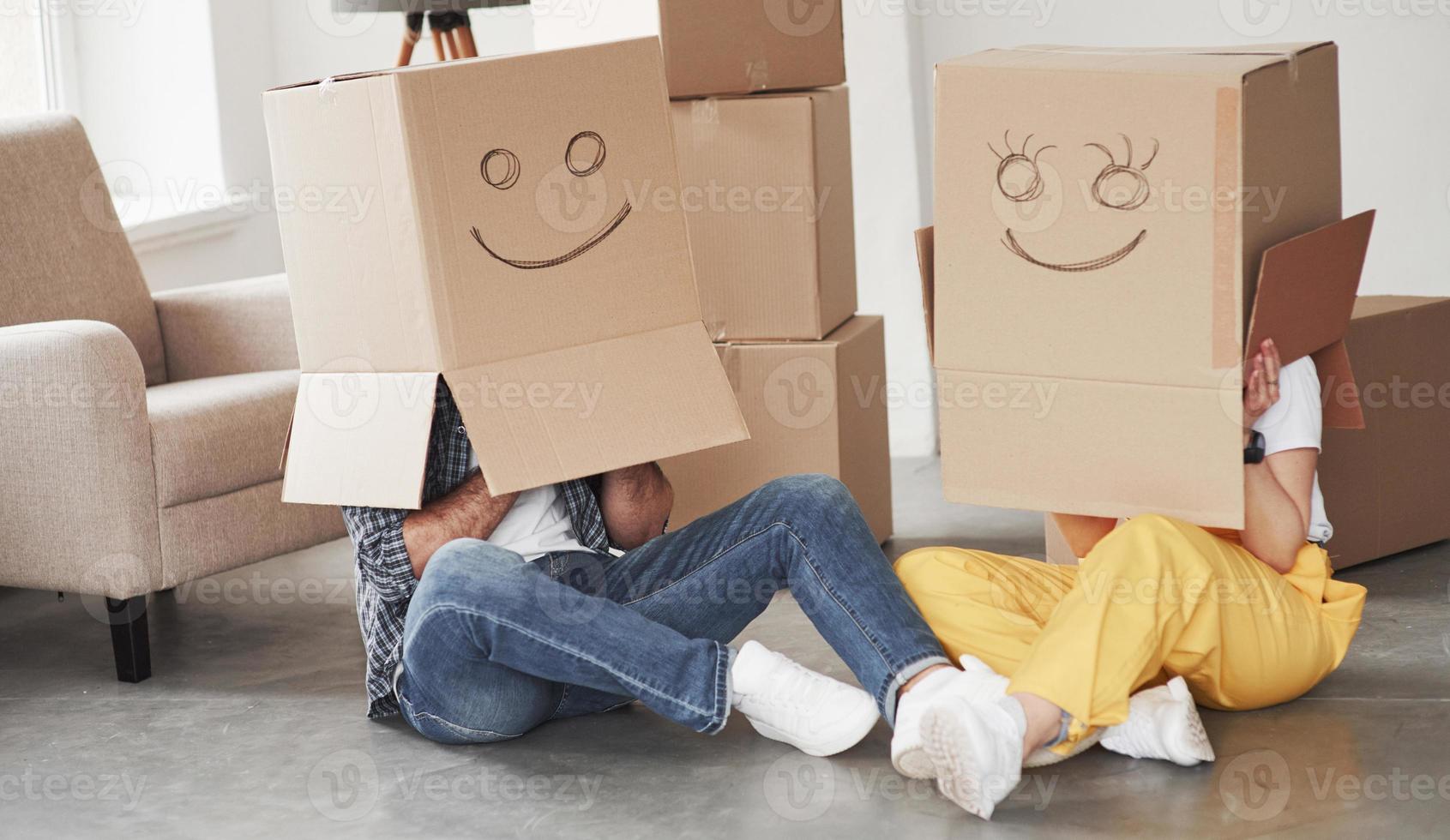 Smiles on boxes. Happy couple together in their new house. Conception of moving photo