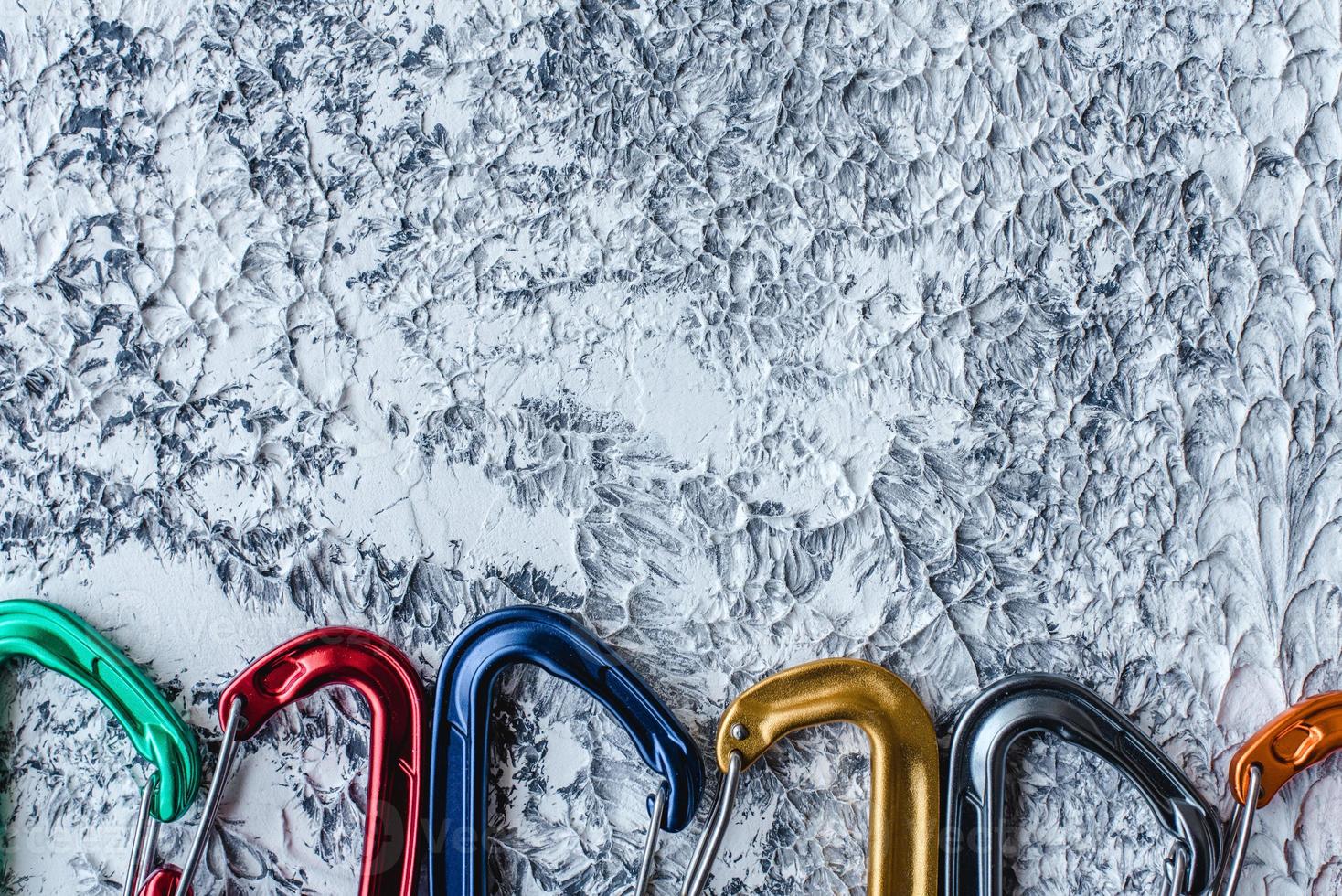 You will not be dissapoined by this. Isolated photo of climbing equipment. Part of carabiner lying on the white and grey colored surface