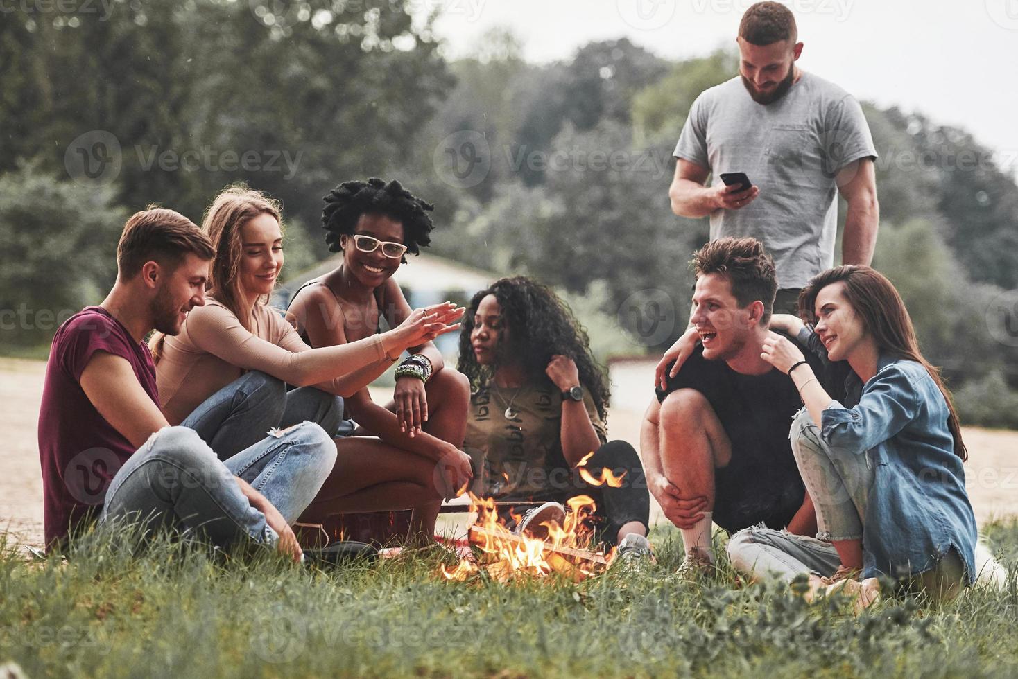 clima cada vez más frío. grupo de personas hacen picnic en la playa. los amigos se divierten el fin de semana foto