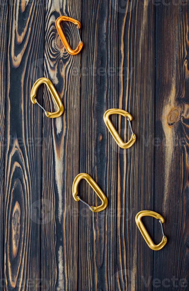 Five objects. Isolated photo of climbing equipment. Parts of carabiners lying on the wooden table