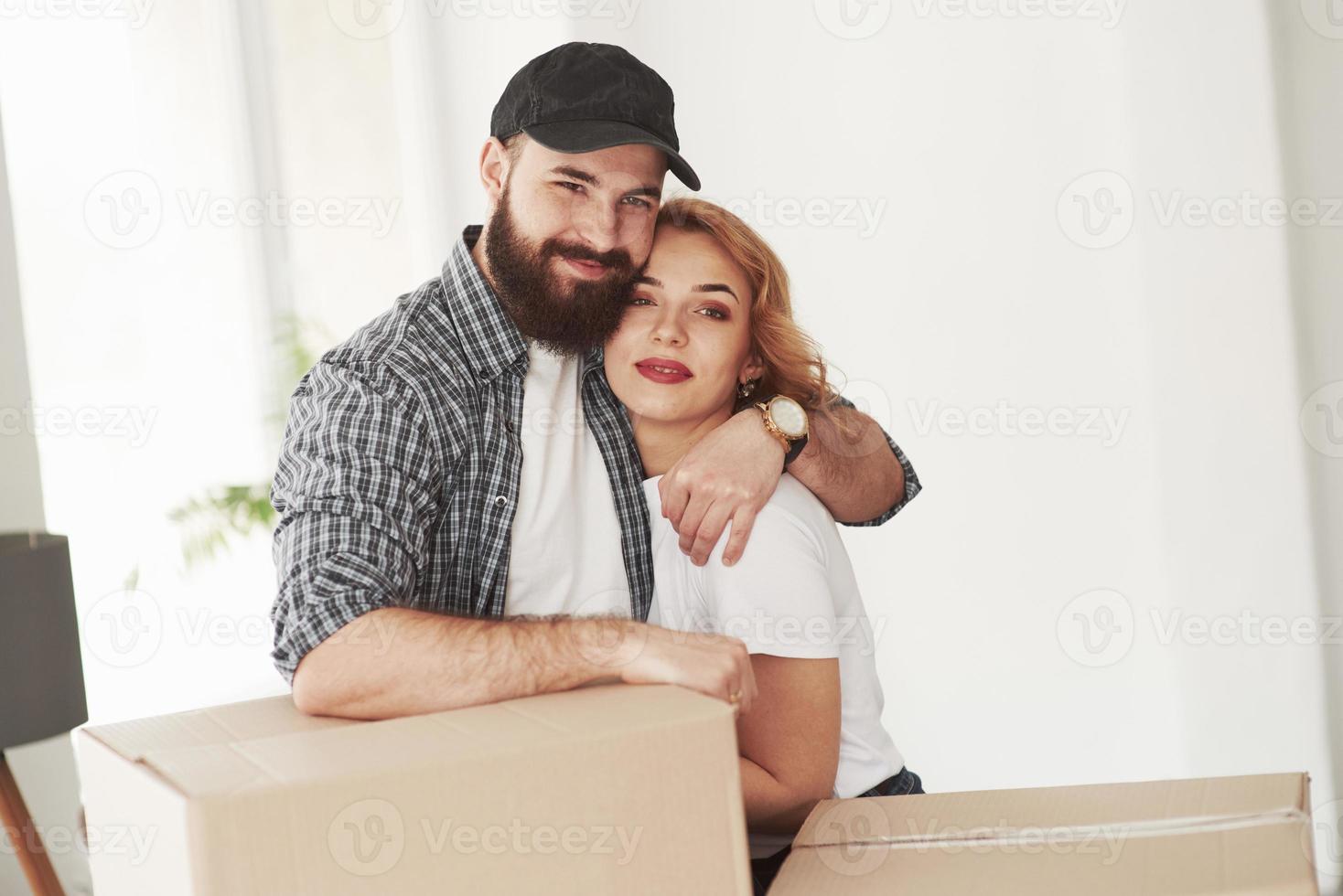 muchas de las cajas. pareja feliz juntos en su nueva casa. concepción de movimiento foto