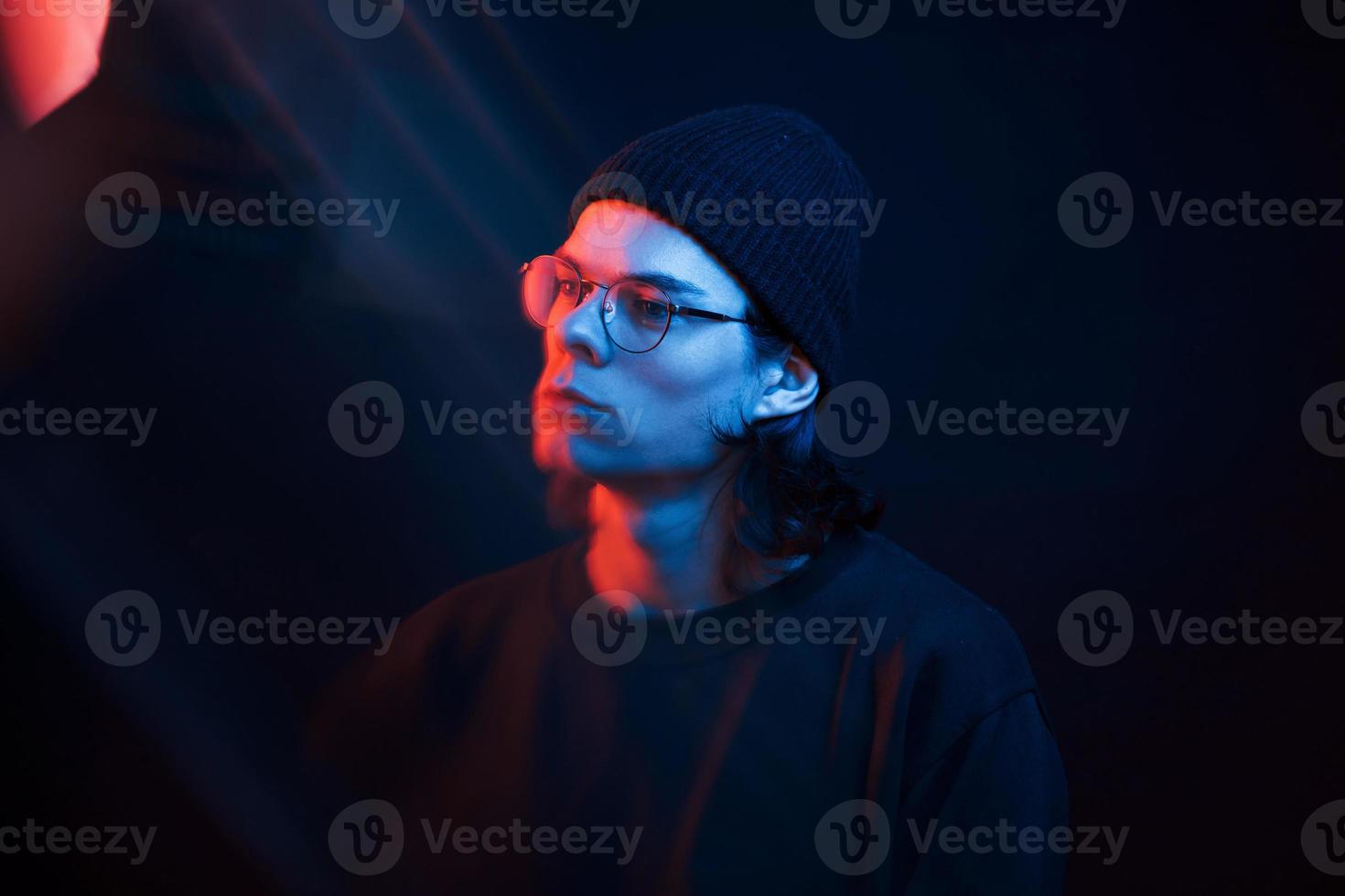 Beautiful reflections. Studio shot in dark studio with neon light. Portrait of serious man photo