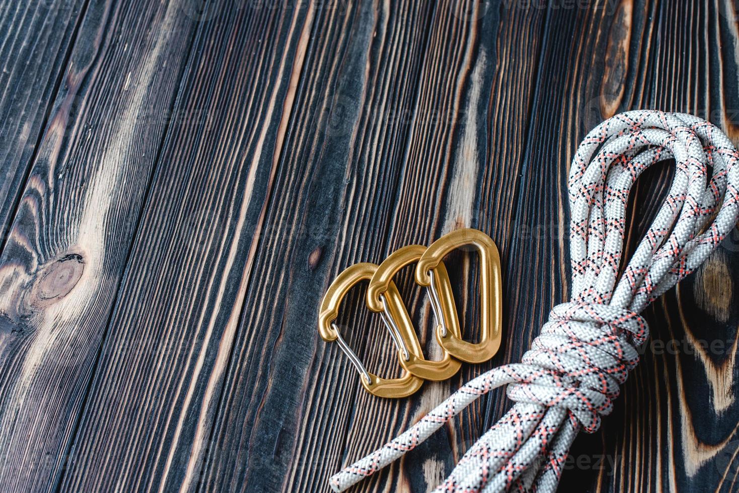 No people. Isolated photo of climbing equipment. Part of carabiner lying on the wooden table