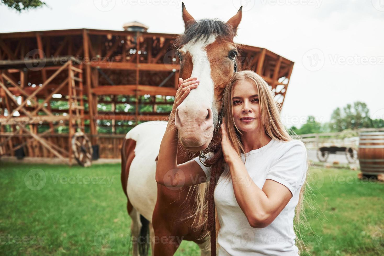 Campo de verano. mujer feliz con su caballo en el rancho durante el día foto