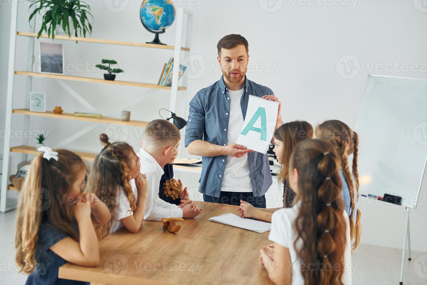 Learn new A letter. Group of children students in class at school with teacher photo