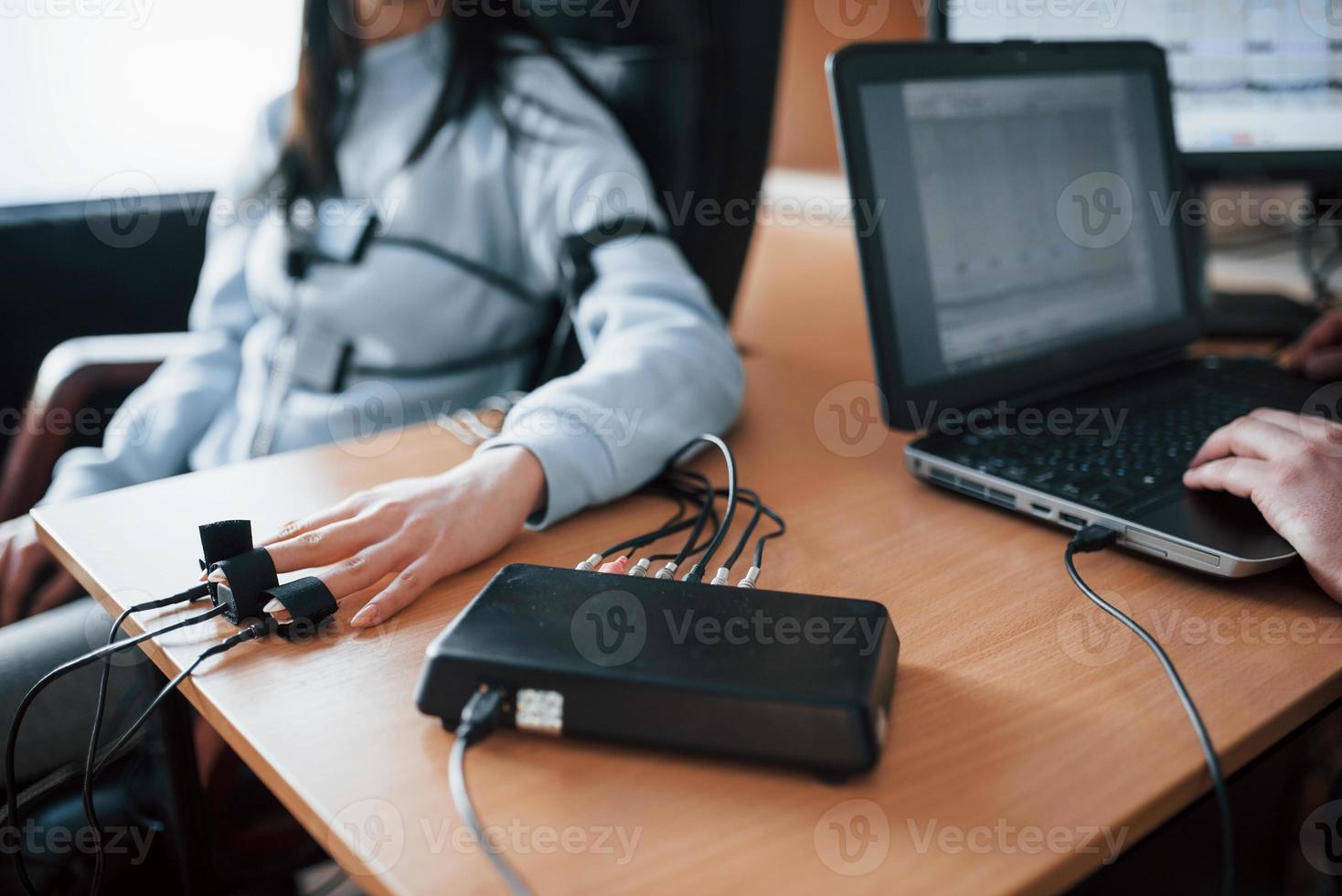 Fidelity verification. Girl passes lie detector in the office. Asking questions. Polygraph test photo