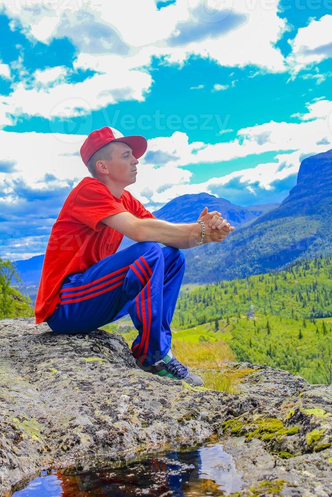 Cool colorful dressed man posing in front of Norway landscape. photo