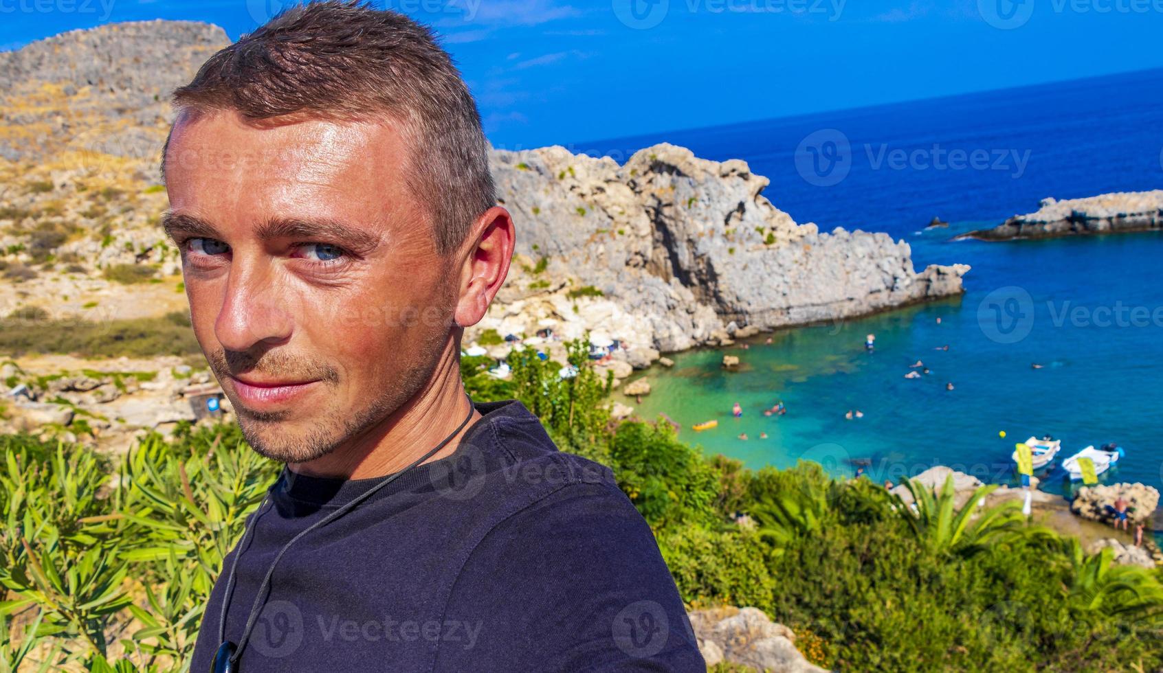 Traveler tourist at St Pauls Bay panorama Lindos Rhodes Greece. photo