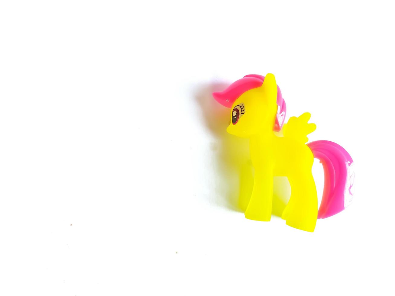 yellow toy horse on white background photo