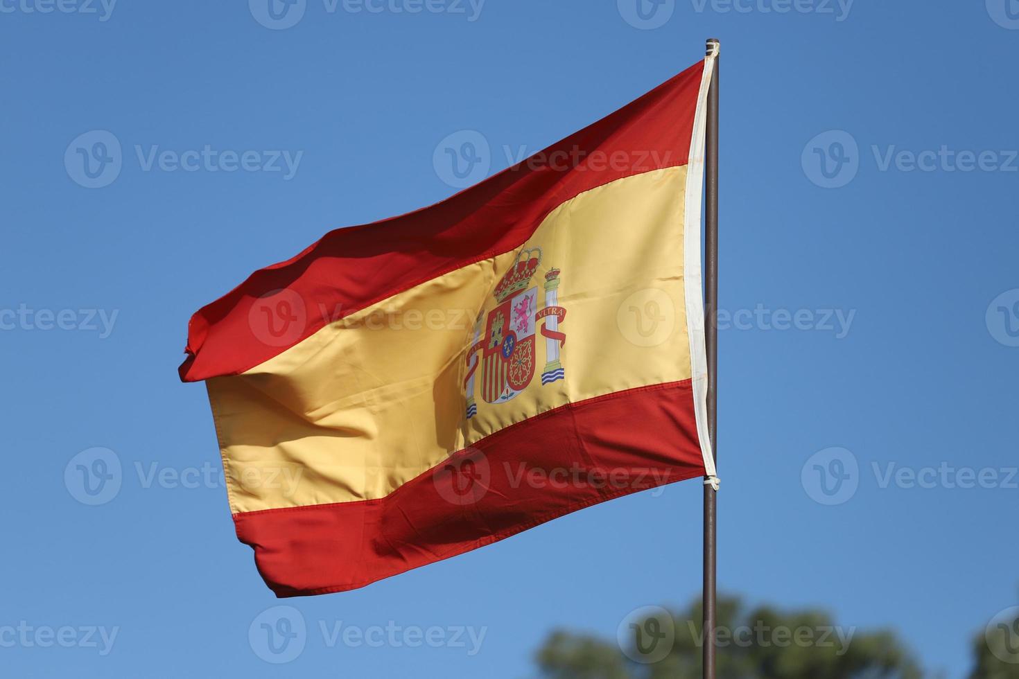 Spanish flag flying on flagpole photo