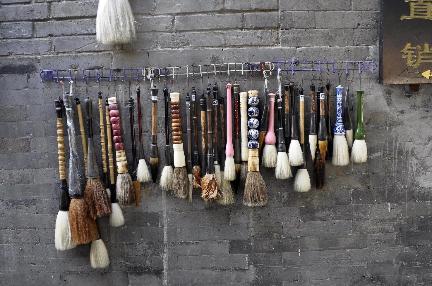 Assorted paintbrushes hanging on a wal. Street market in Pekin photo