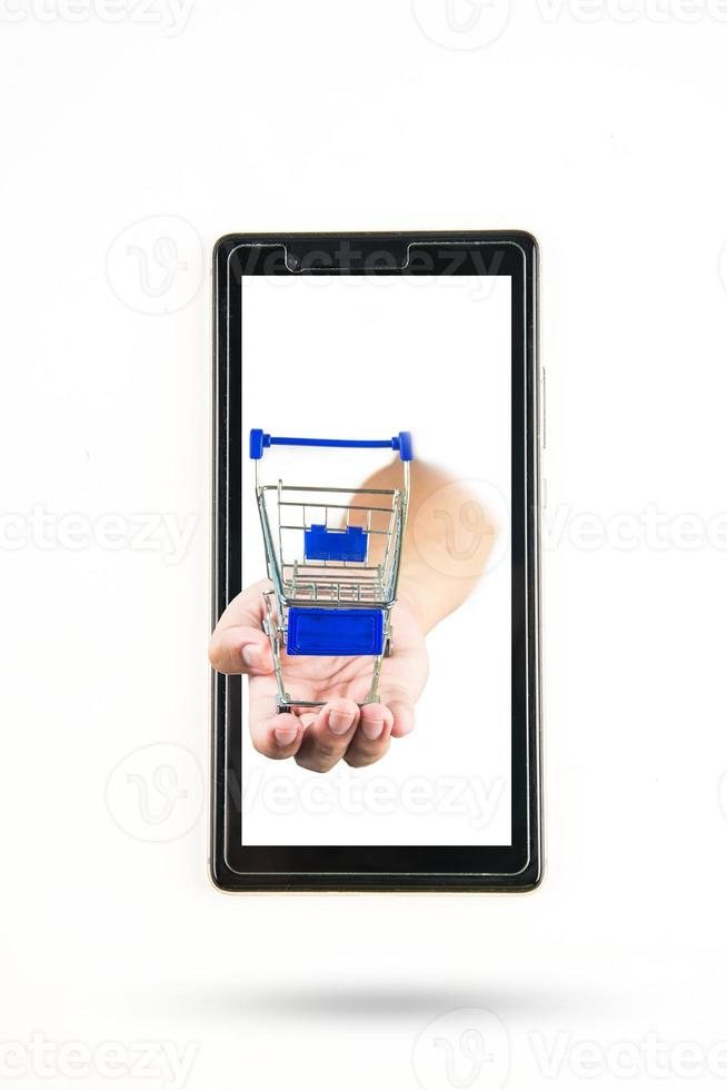 shopping cart in hand  with smart phone on white background photo