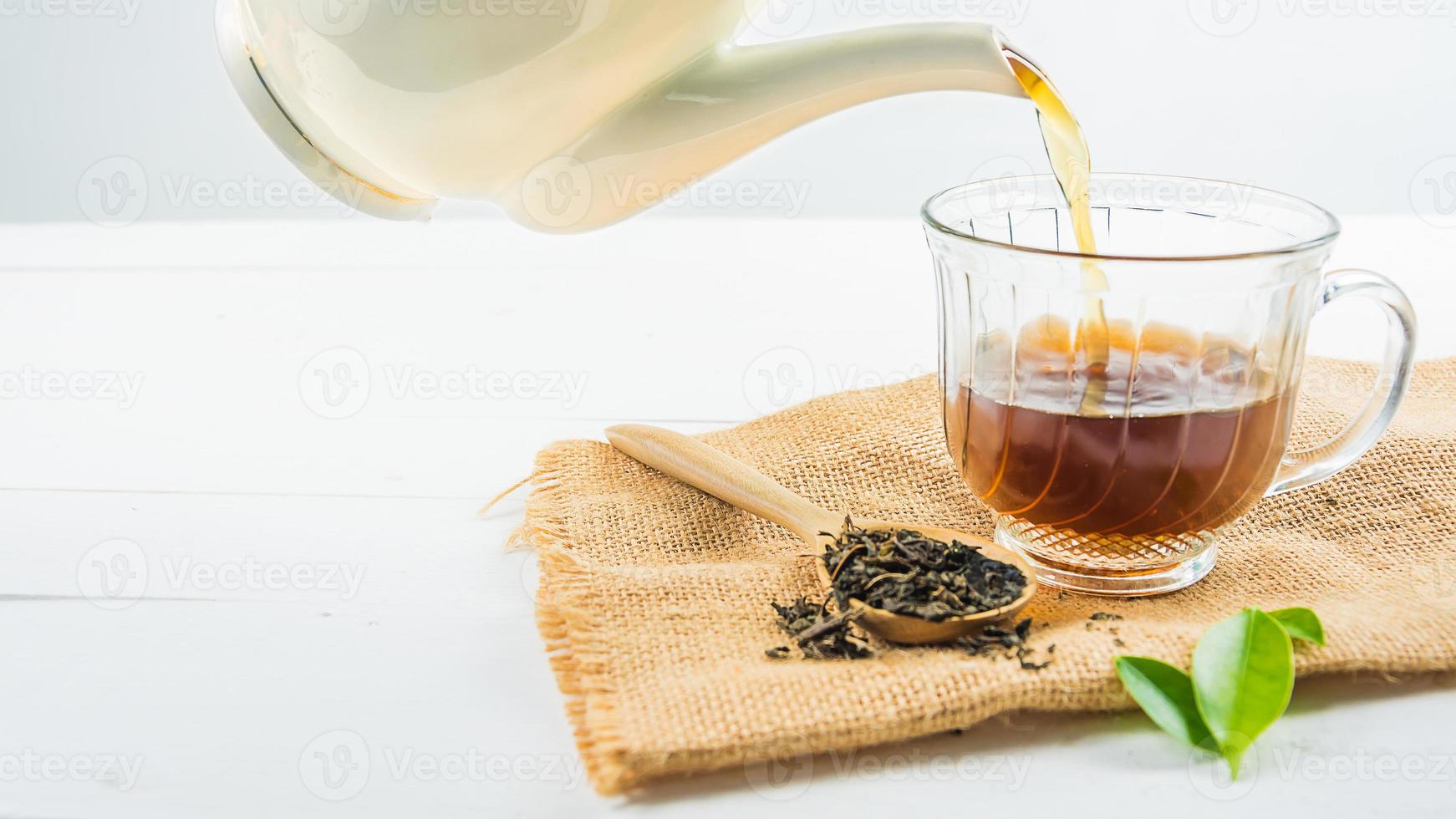 té con vaso de té en madera blanca foto