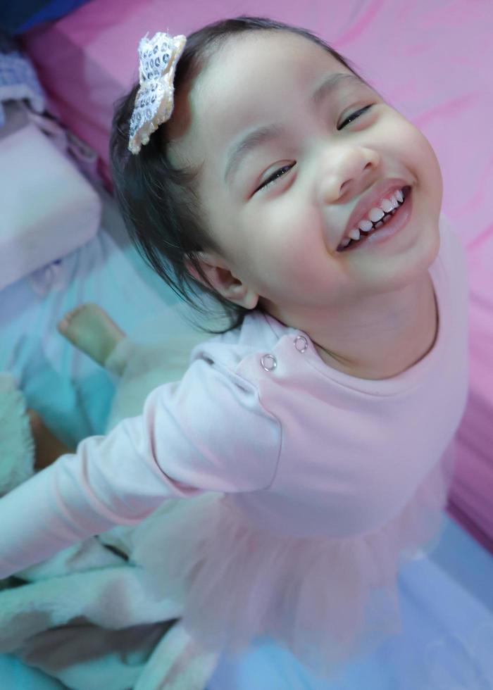 niña asiática sonriendo alegremente mirando a la cámara, tailandia. concepto de emoción infantil. foto