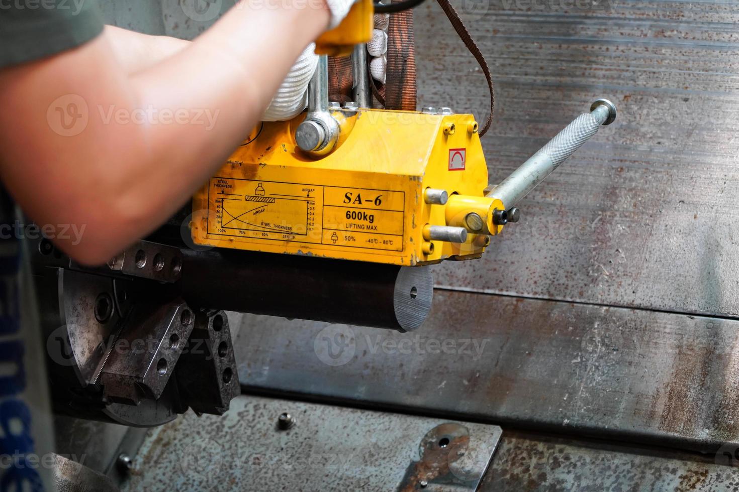 mechanic uses a magnet to lift the workpiece controlled by hand. photo