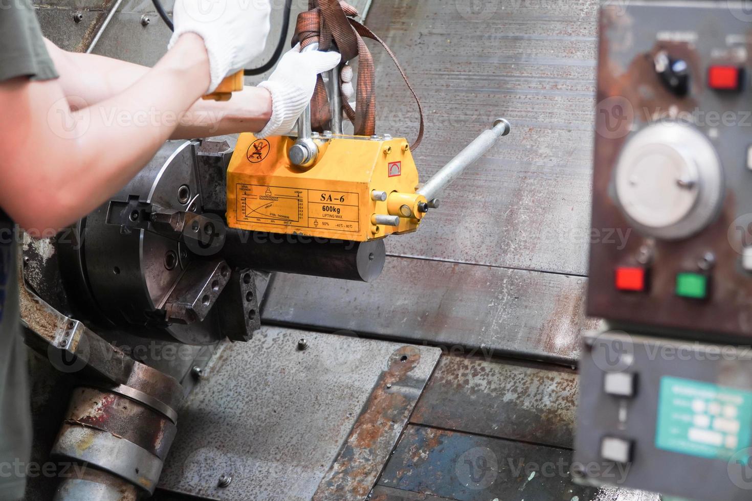 mechanic uses a magnet to lift the workpiece controlled by hand. photo