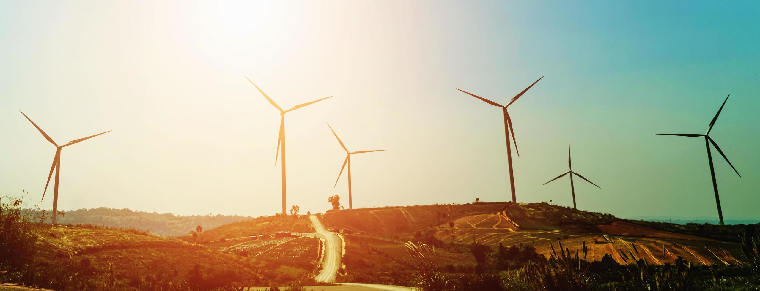 concept idea eco power energy in nature. wind turbine on hill and sunset photo