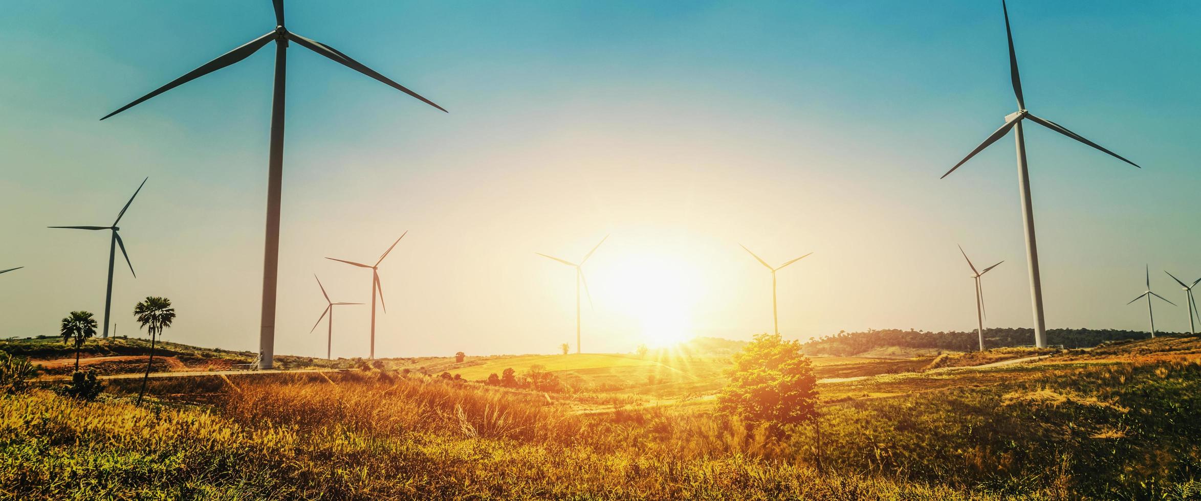 concept idea eco power energy in nature. wind turbine on hill and sunset photo