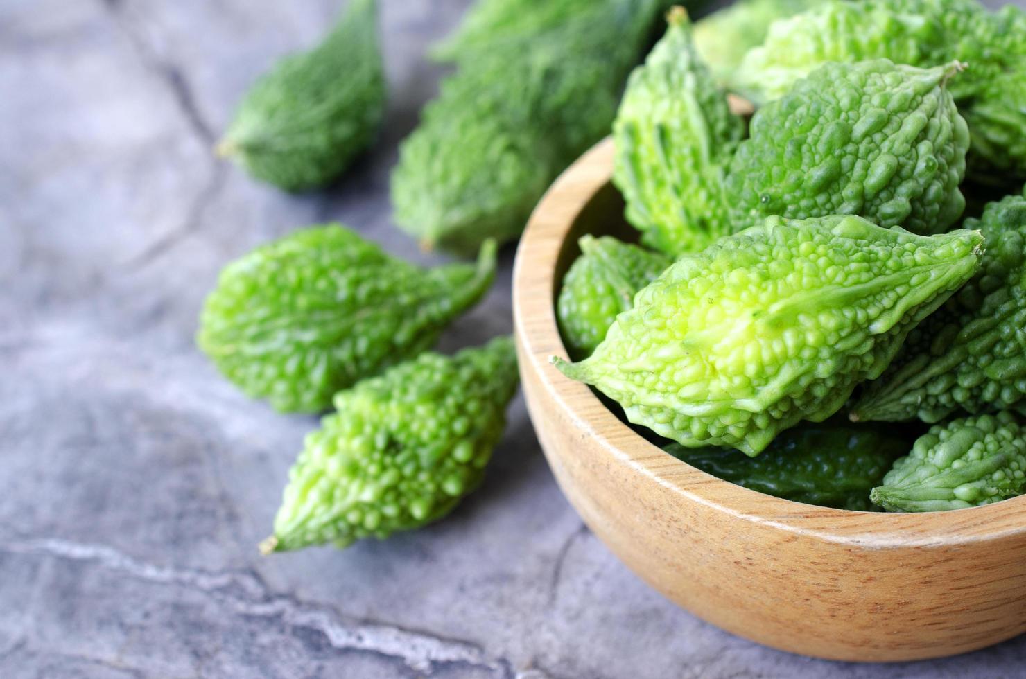 Close up of green bitter vegetable in wooden bowl raw food backgrounds photo