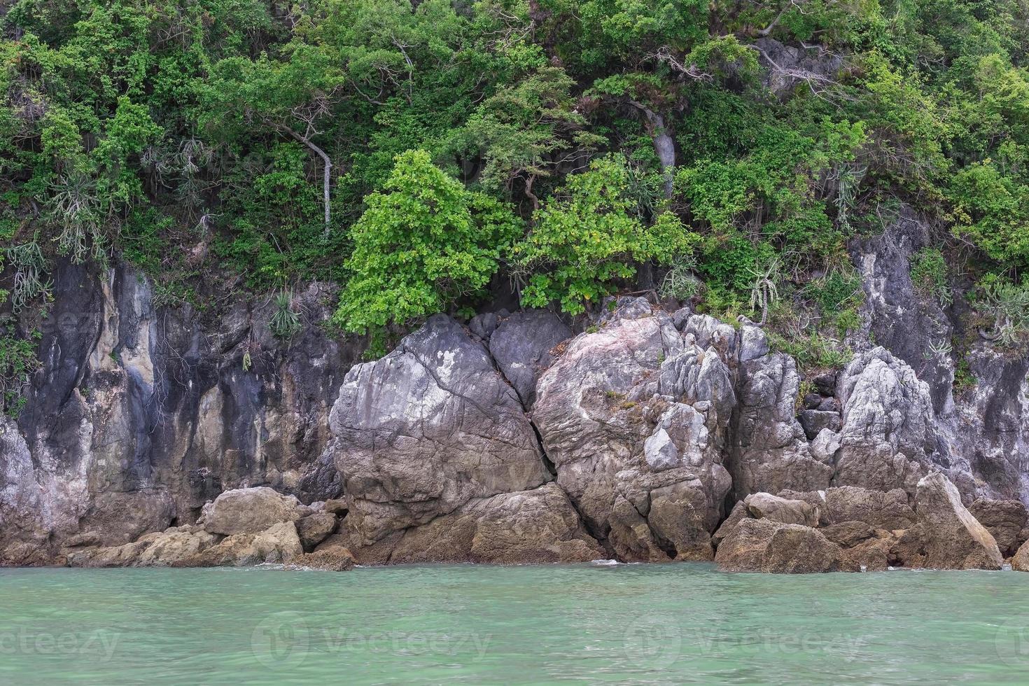 A picture of the sea with granite cliff mountain, it is one type of rock which forms from magma as a beautiful natural theme. photo