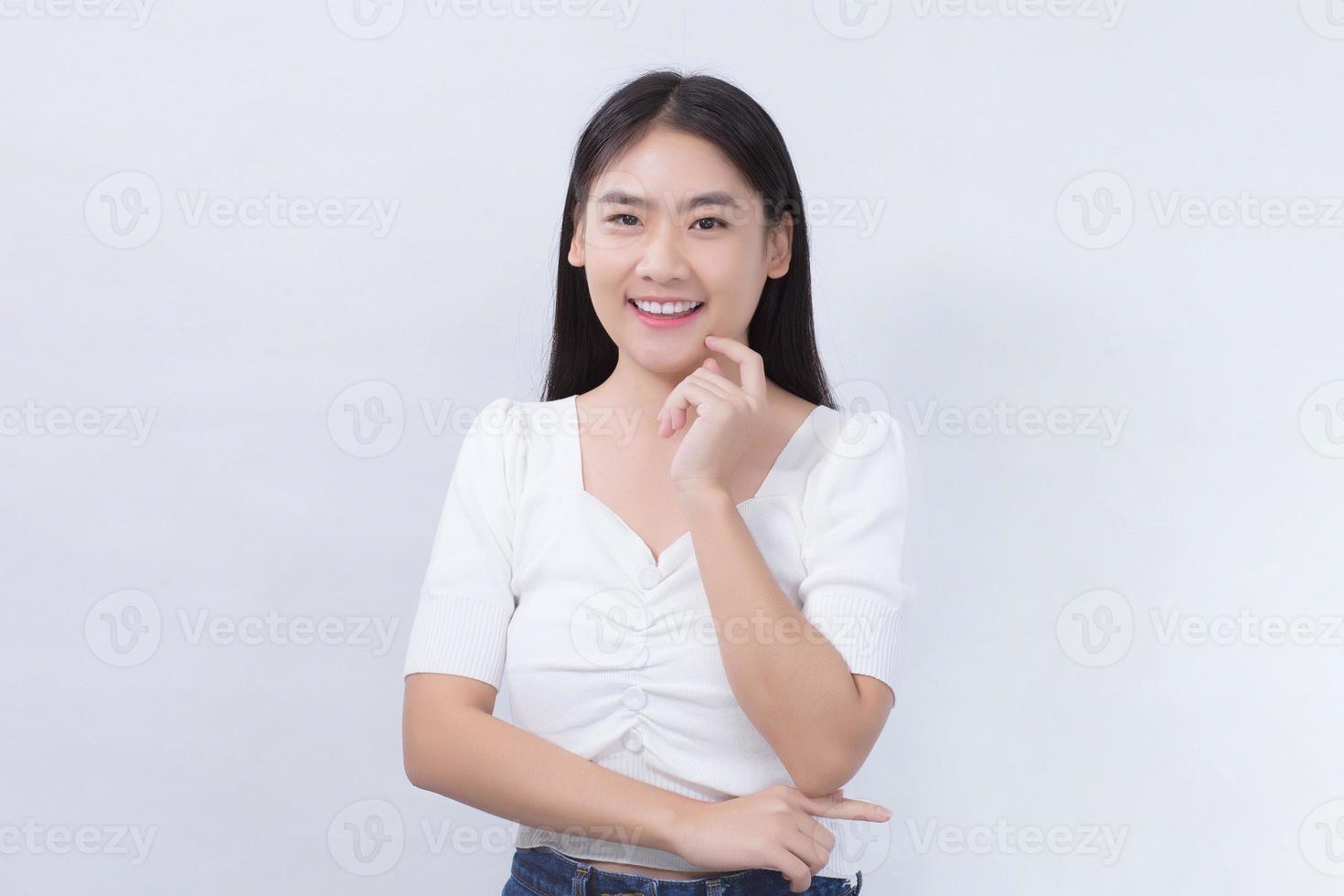 Portrait Asian beautiful woman in white shirt touches her face and smiles on white background studio. photo