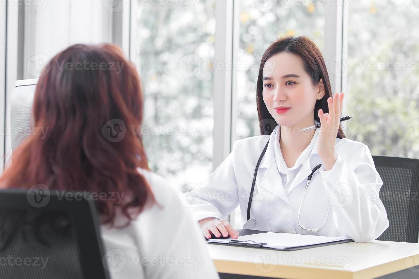 Asian professional  woman doctor suggests healthcare solution to her patient elderly in examination room at hospital. photo