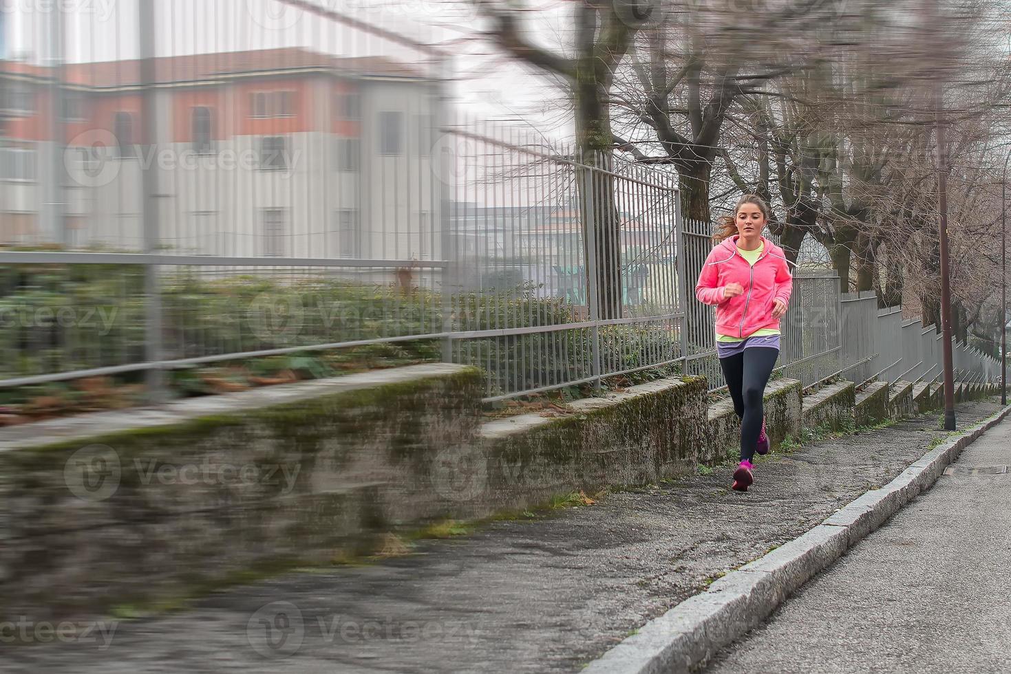 Girl runs on the sidewalk in the city photo