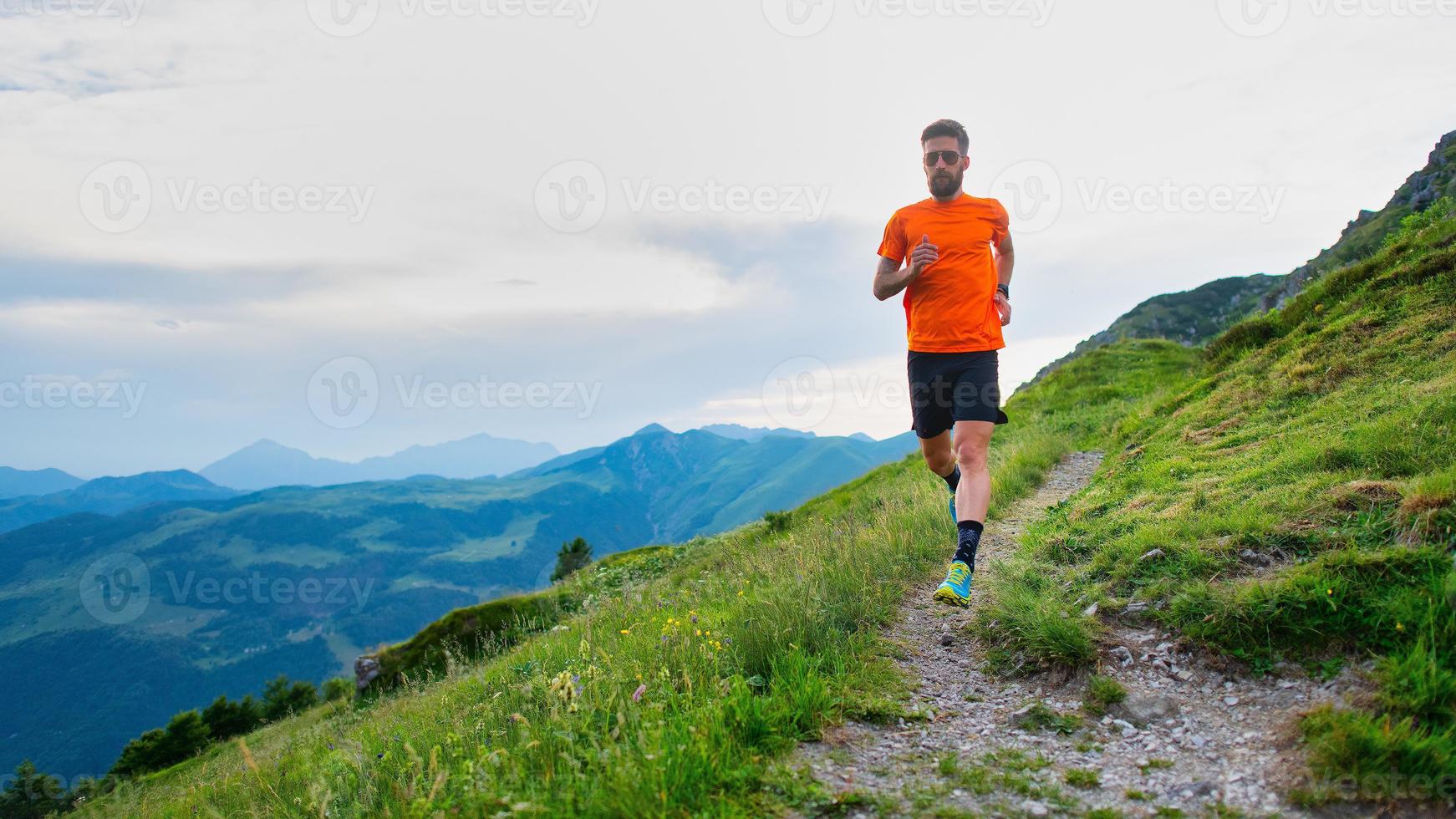 atleta de trail running durante un entrenamiento en sendero de montaña foto