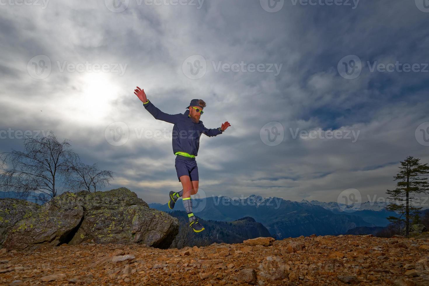 atleta de trail running salta entre las rocas foto