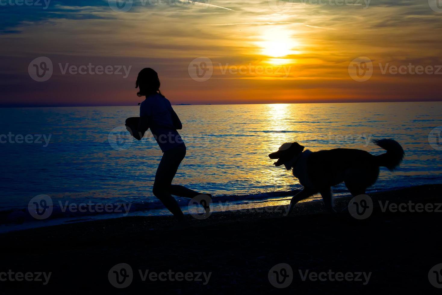 chica con perro en la playa foto