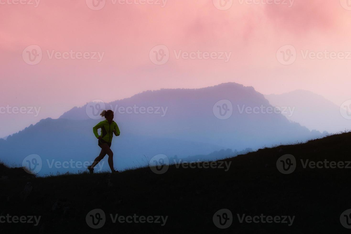 chica deportiva corre sola en las montañas foto