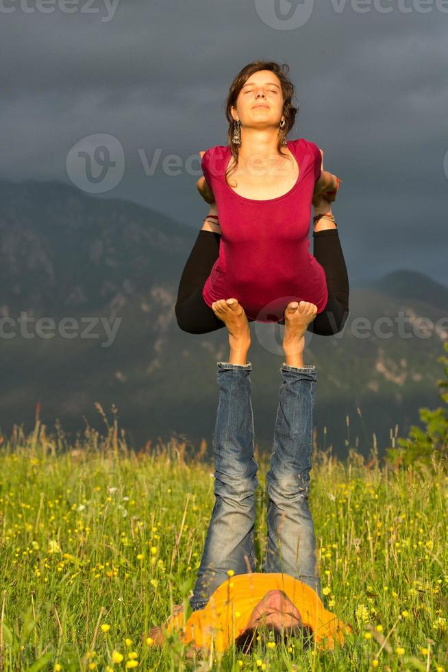Positions Acroyoga girl of male in nature in the mountains photo