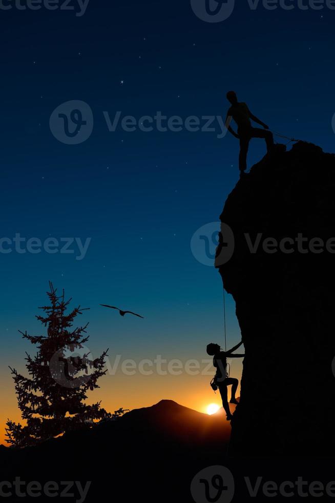 Team of two mountaineers roped climb the mountain. photo