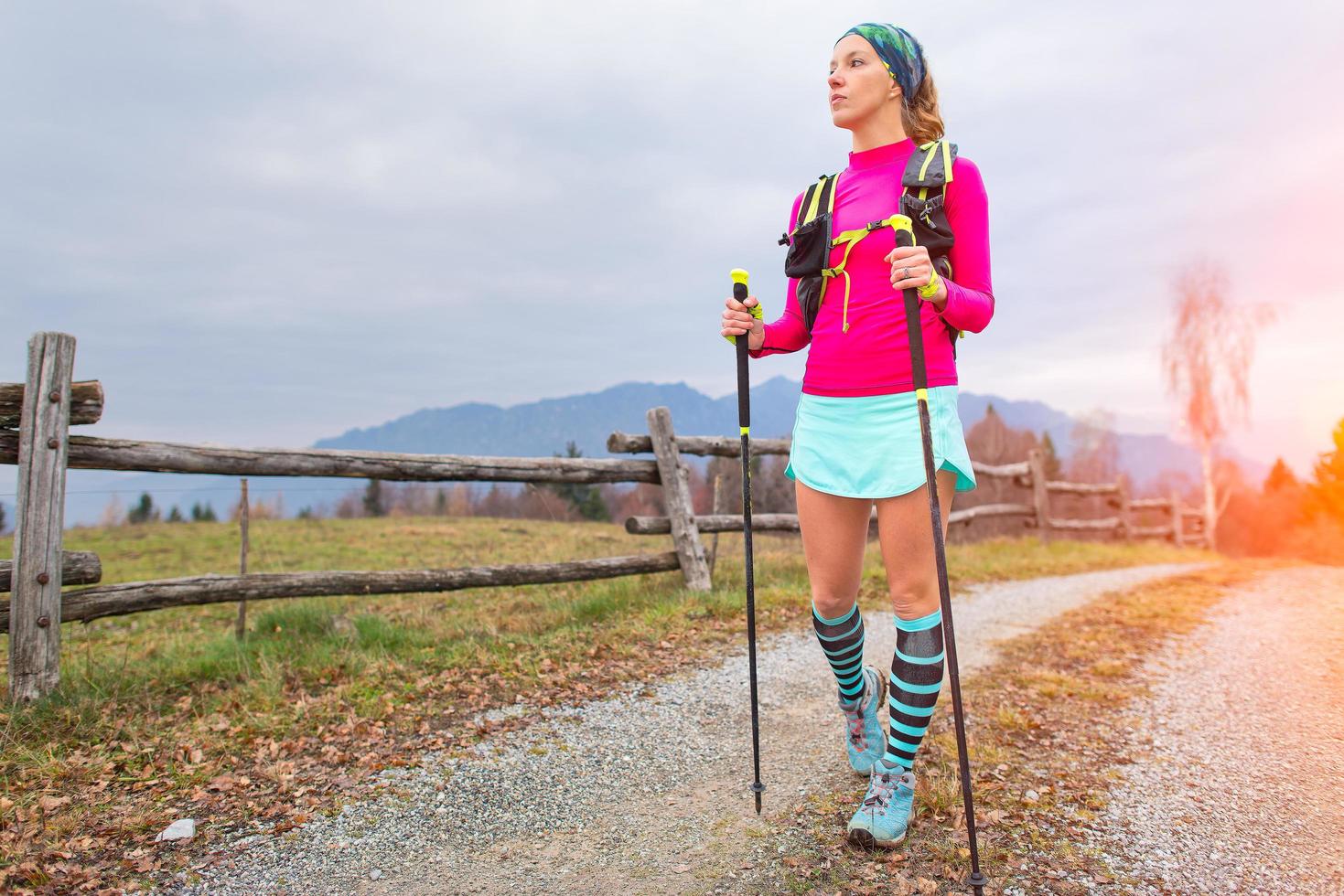 Sporty girl observes landscape during a Nordic walking trek photo