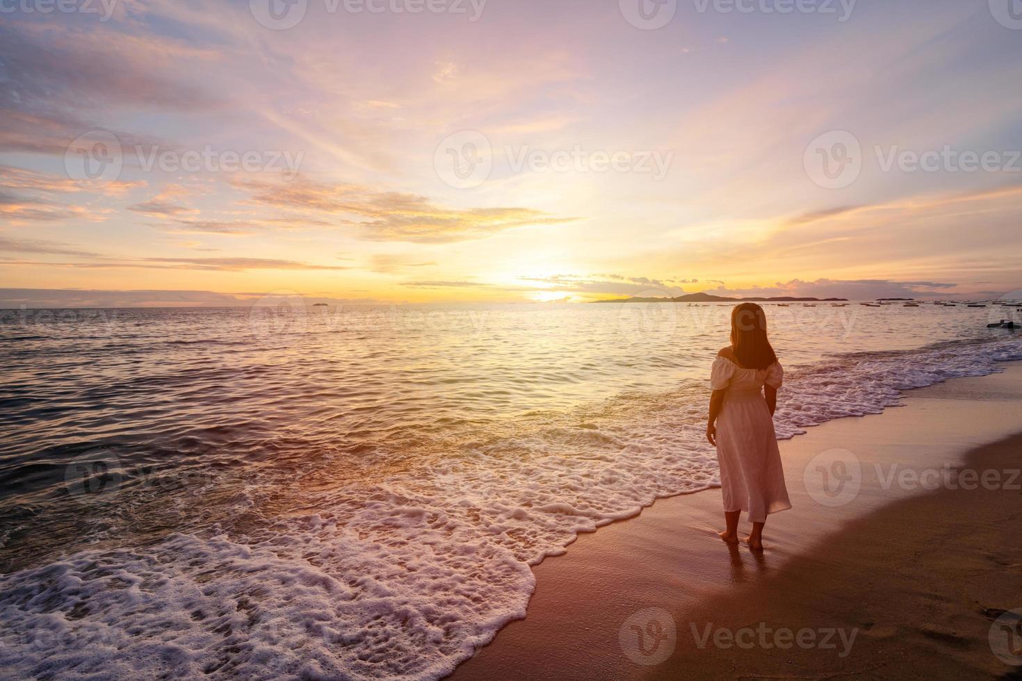 Lonely young woman walking and enjoying beautiful Sunset on the tranquil beach, Travel on summer vacation concept photo