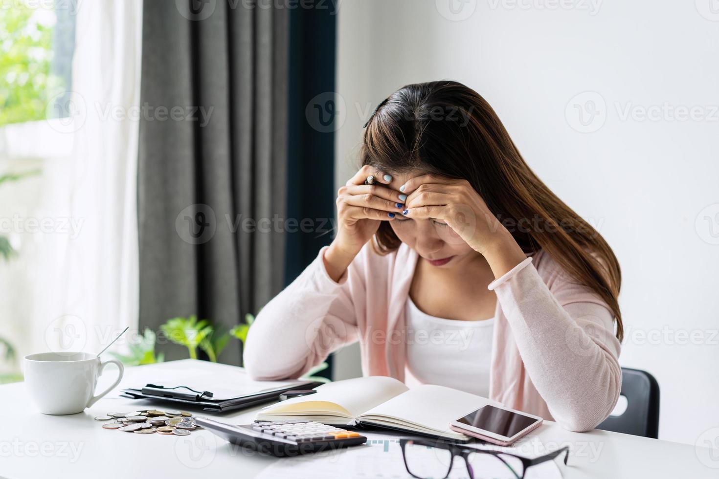 mujer joven estresada que calcula los gastos mensuales de la casa, los impuestos, el saldo de la cuenta bancaria y el pago de las facturas de las tarjetas de crédito, los ingresos no son suficientes para los gastos. foto