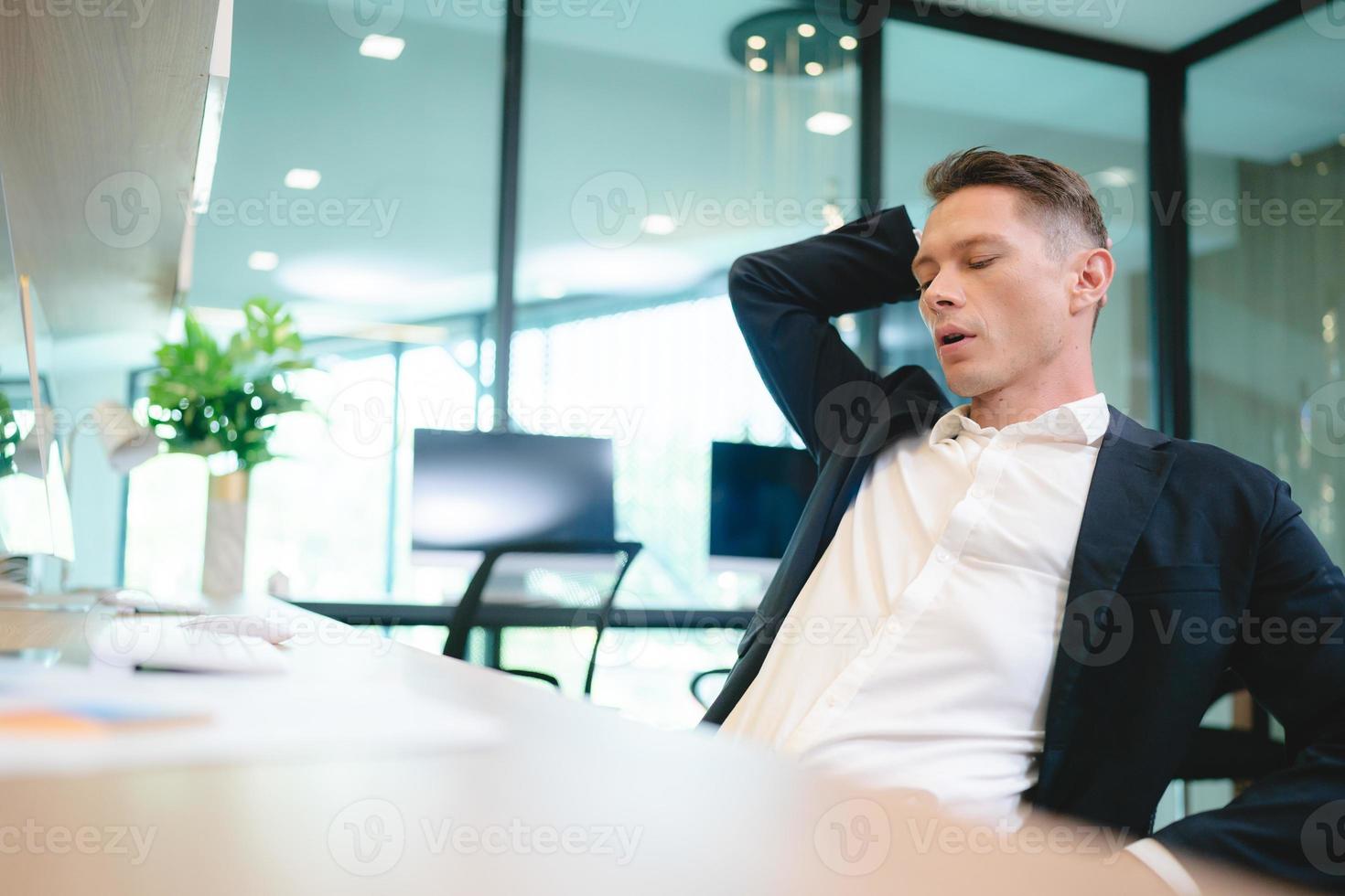 empleado y gerente de oficina cansado y estresado descansando y durmiendo en el escritorio con computadora y teclado después de un día de tensión para relajarse y tomar un descanso del exceso de trabajo y las horas extra foto