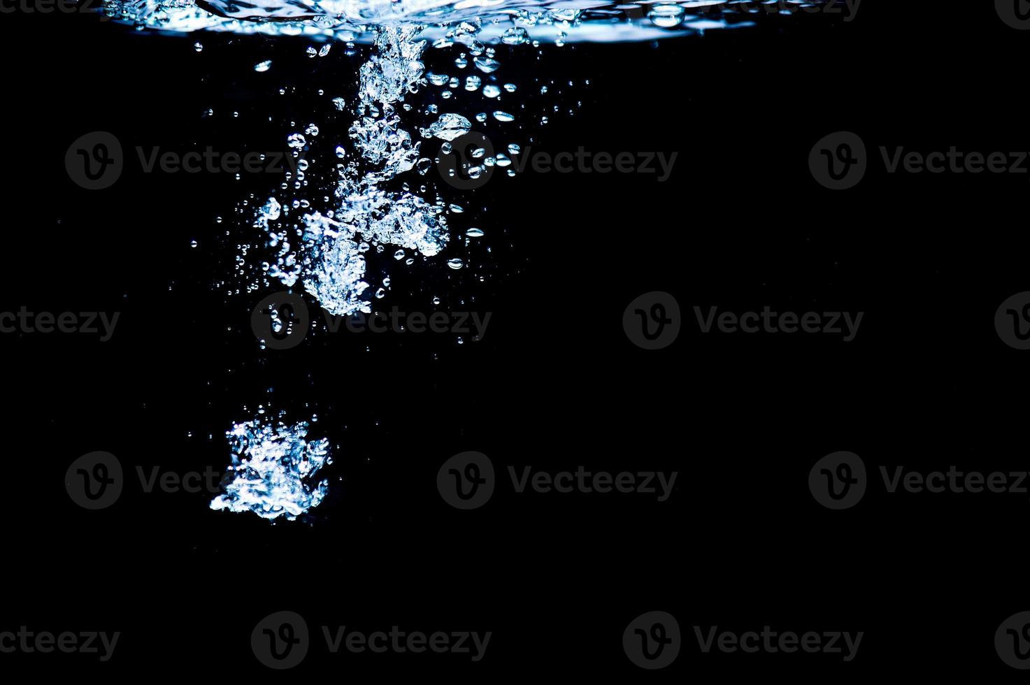 Water bubbles isolated on black background, close up view. Rippling liquid surface, an abstract background for overlays design photo